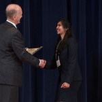 Doctor Potteiger shaking hands with an award recipient in a black blazer and skirt